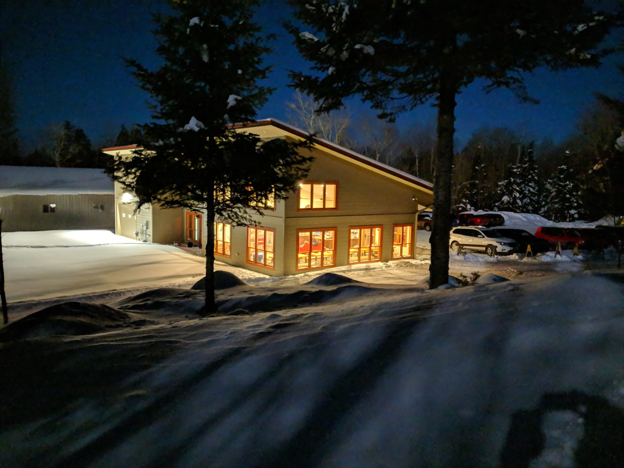 WinMan chalet with lights on at night
