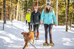 Group snowshoeing with their dog at WinMan in the Winter