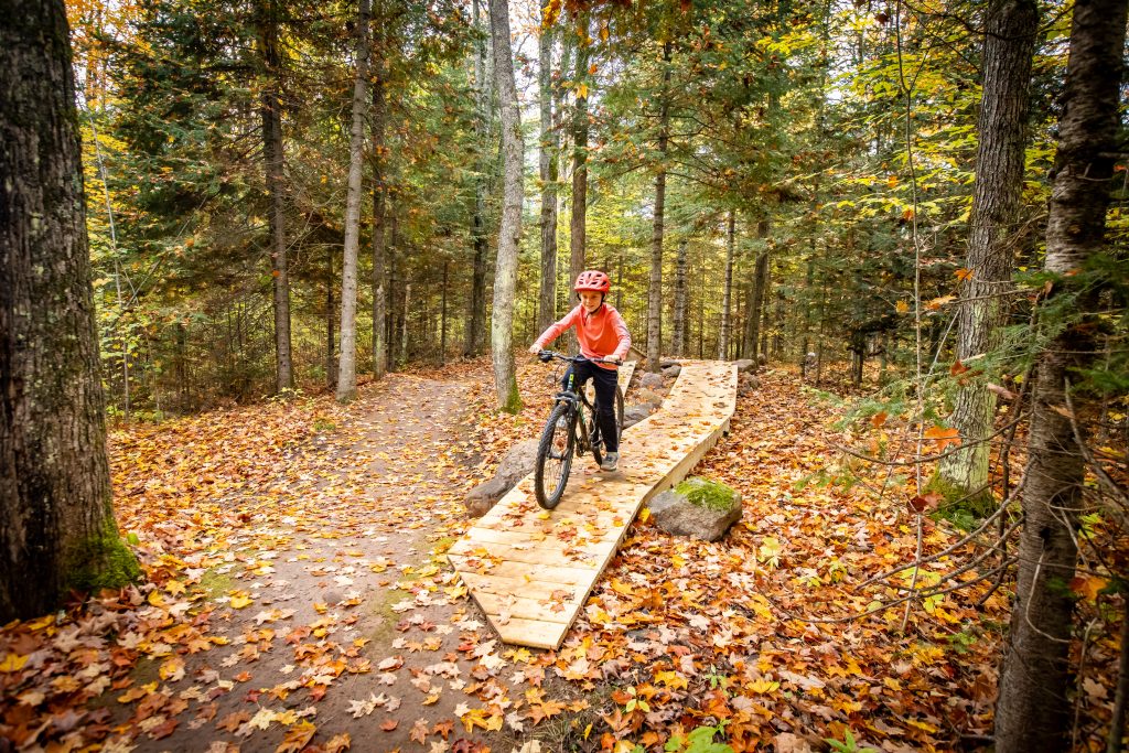 Boy riding a bridge feature on Scout Trail in the Fall