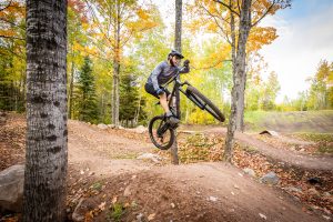 Mountain biker jumping with flare in the skills park