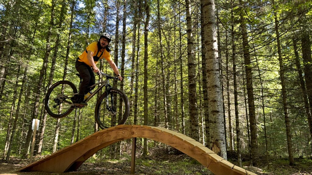 mountain biker on a wooden feature on scout trail