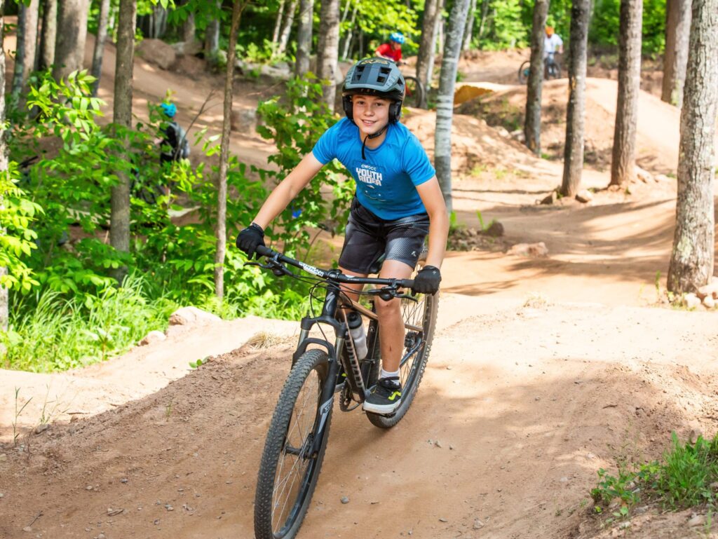 Young kid riding a mountain bike on the skills park at WinMan